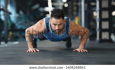 Strong guy making plank or push ups exercise, panorama