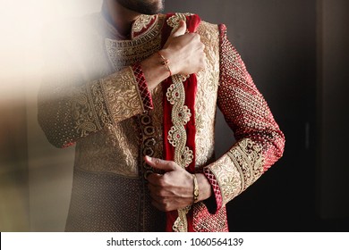 Strong Handsome Indian Groom Holds His Hands Over Wedding Suit