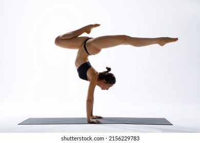 Strong handstand. Athletic slim woman. Yoga pose. White studio background. Asana. - Powered by Shutterstock