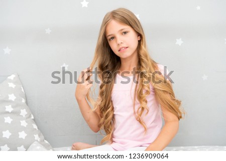 Strong and healthy. Girl with long curly hair grey background. Things you shouldnt do at night for healthier hair. How style hair before go to bed. Hair care tips. Easy way keep nice hairstyle.