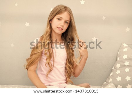 Strong and healthy. Girl with long curly hair grey background. Things you shouldnt do at night for healthier hair. How style hair before go to bed. Hair care tips. Easy way keep nice hairstyle.