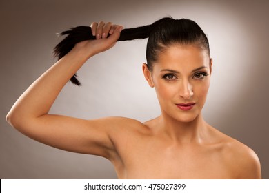 Strong Healthy Hair - Woman Holds A Pony Tail Over Gray Background