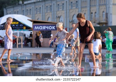 Strong heat in the city: laughing children playing with fountain water jets at the square. June 5, 2018. Kyiv, Ukraine