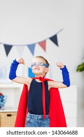 Strong Kid Wearing A Superhero Costume And Showing His Muscle