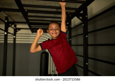 Strong Latin Kid Train After School For Health And Joy. Child Climbing High Machine Changing Hands. Interesting In Sport, Work On Endurance. Active Lifestyle, Pastime, Workout Concept