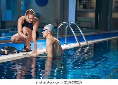 Strong male training in pool in evening time with coach - Powered by Shutterstock