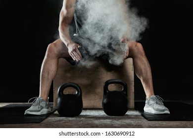 Strong man applying magnesium powder on hands before training with kettlebells in gym, closeup - Powered by Shutterstock