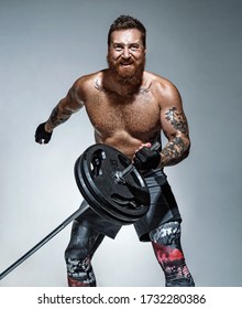 Strong man does landmine exercises, workout with barbell. Photo of sporty man on grey background. Strength and motivation