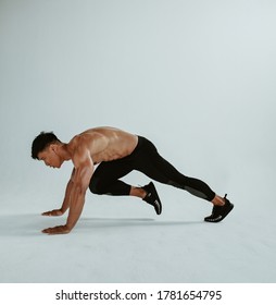 Strong Man Doing Mountain Climbers Cardio Exercise. Fit Young Man Doing Cross Body Workout Over White Background.