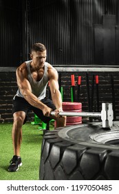 Strong Man Is Hitting Tire With A Sledgehammer During His Training Workout