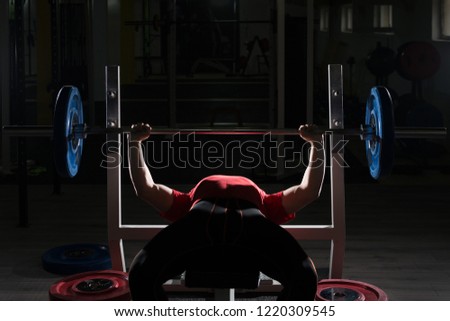 Strong Man Lifting Heavy Barbell During Powerlifting Workout in Gym