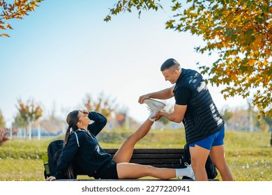 Strong man reminded his girlfriend about something while he is stretching her feet. She cannot believe that forgot that