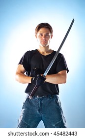 Strong man with samurai sword. On soft blue background.
