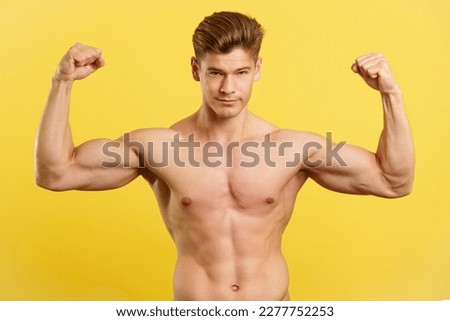 Strong man showing biceps while looking at camera