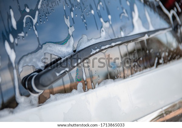 strong man\
washing car at self carwash\
outdoors