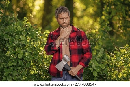 Strong man work in forest. Man in forest with axe. Lumberjack carries axe. Deforestation. Mature sweating man with axe. Lumberjack in woods with ax. Lumberjack tired with heavy axe. Forest cutter