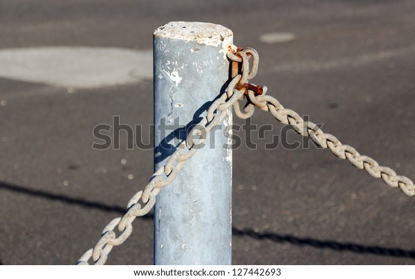 Strong metal chain used with\
metal poles  and  locks to secure car yards at night  against\
thieves .
