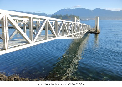 A Strong, Metal Walkway Or Gang Plank Leads To A Marina Dock. 