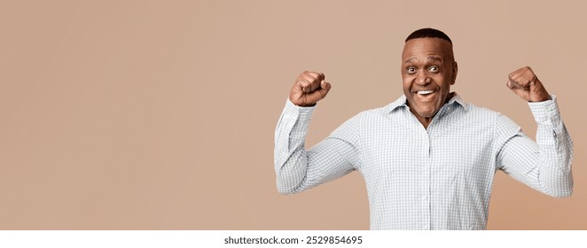 Strong middle aged african american man showing biceps at camera, orange panorama background - Powered by Shutterstock