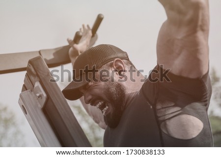strong mighty athlete man with beard lifting heavy weight on sport fitness