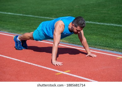 Strong muscles. male strength and power. sportsman in plank. athlete do pushups. train his core muscles. man doing push ups exercise on stadium. fitness gym outdoor. muscular athletic guy training.