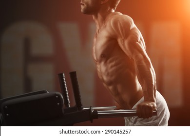 Strong muscular bodybuilder doing exercise on bars in the gym. Part of fitness body. Sports and fitness. Fitness man in the gym. Fitness training - Powered by Shutterstock