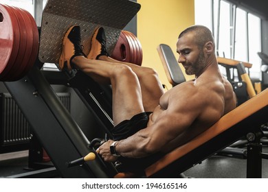 Strong And Muscular Bodybuilder Doing A Seated Leg Press Exercise In A Gym