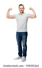 Strong, Muscular Handsome Man In A White T-shirt, Tightening His Biceps, Smiling. Representation Of Power. Studio Shot, Full Body.