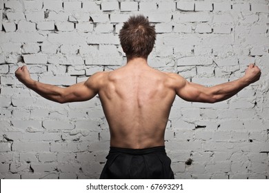 Strong Muscular Man Back At White Wall Background In Hard Rage Standing