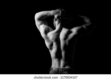 Strong Muscular Man Holding His Hands Behind His Head. Perfect Shoulders And Back Muscles. Dramatic Light