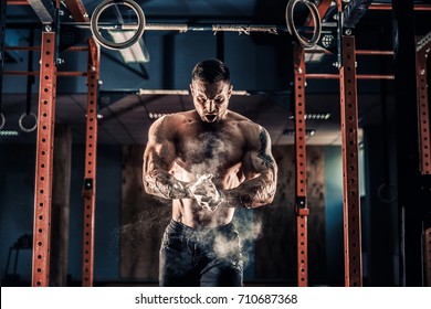 Strong muscular man preparing for workout in crossfit gym. Young athlete practicing cross-fit training - Powered by Shutterstock