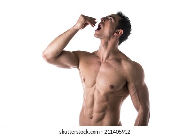 Strong Muscular Man Taking Diet Supplements Or Pharmaceutical Medication Standing Shirtless With His Mouth Open And Head Tilted Back As He Drops A Pill From His Hand Or Places Something In His Mouth