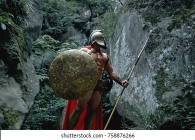 Strong Muscular Medieval Warrior In Battledress Posing With A Shield And Spear.