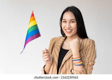 Strong non-binary LGBT person waiving rainbow flag for LGBT awareness pride month
