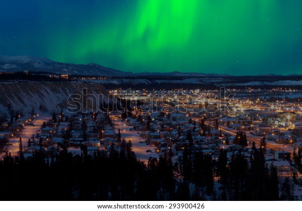 Strong northern lights (Aurora borealis) substorm\
on night sky over downtown Whitehorse, capital of the Yukon\
Territory, Canada, in\
winter.
