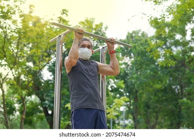 A Strong Old Man Doing Exercise Outdoor By Hang- Bar Equipment In The Park. Concept Health Care In Elderly People, Lifestyle                               