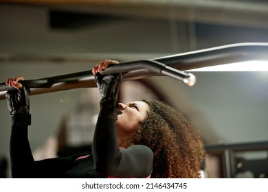 Strong Is The Only Option. Shot Of A Young Woman Doing Pull Ups At The Gym.