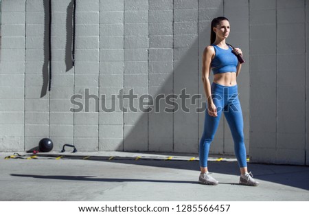 Strong powerful confident stance portrait by beautiful athletic model trainer in sportswear