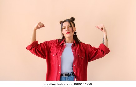 Strong powerful stylish woman with tattoo, raises arms and shows biceps. Feminism and women power - Shutterstock ID 1980144299