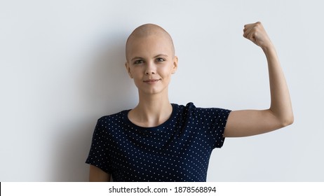 Strong Powerful Young Female Ill With Cancer Look At Camera Raise Fist Show Biceps Inspire To Fight. Motivated Sick Hairless Woman Encourage Oncology Patients Never Give Up. Studio Portrait On White