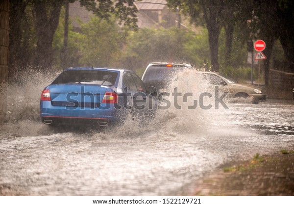 Strong rain in the city. Street of the city flooded\
after heavy rains
