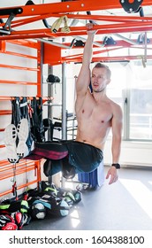 Strong Shirtless Male Athlete Shows Calisthenic Moves Hanging On Pull Bar One Arm Leg Raises Or L-sit Hold