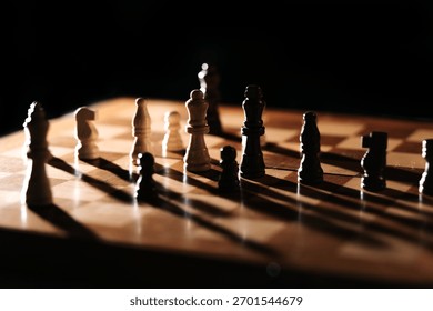 Strong side light casts long shadows as white and dark pieces face off; a moody chessboard scene about tension, balance and strategic positioning.