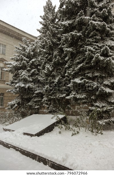 Strong snowfall in city streets in winter. Cars\
are covered with snow, slippery road. Bad weather in winter: heavy\
snow and blizzard. Pedestrians go under heavy snow. Winter and\
snowstorm, snowfall