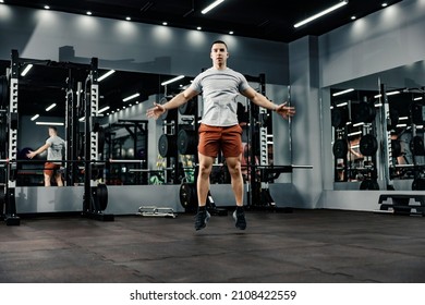 A Strong Sportsman Doing Jumping Jacks In A Gym. Fitness And Gym Workout.