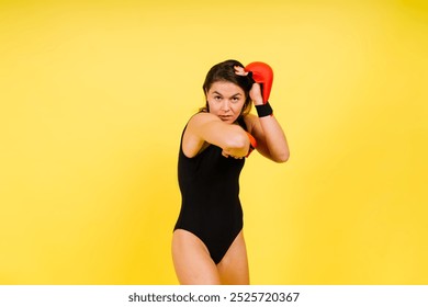 Strong sportswoman in boxing gloves prepared high kick. Isolated on white, red, yellow background - Powered by Shutterstock