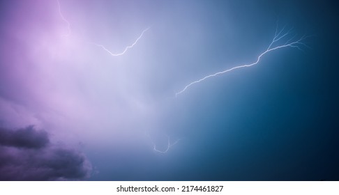 A strong storm with bright lightning illuminating ominous clouds. Exotic image of the texture of storm clouds. Adverse weather conditions. Picturesque photo wallpaper. Climate change. Force of nature. - Shutterstock ID 2174461827