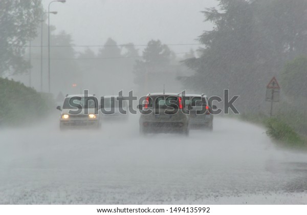 The\
strong storm with heavy rain on the road with poor visibility of\
cars. Concept of the danger of driving in bad\
weather