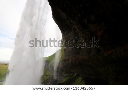 Strong stream of water falling from the waterfall Seljalandsfoss in Iceland, popular tourist landmark. Concept of power of water. One of rare waterfalls one can walk behind.