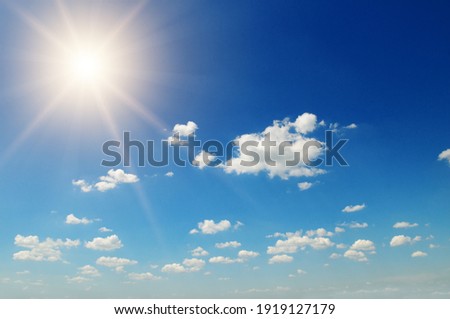 Strong sun, blue sky and cumulus clouds.